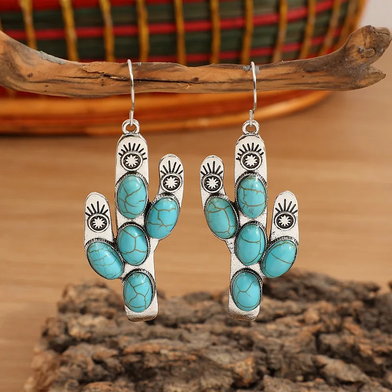 Boucles d'oreilles pendantes en forme de cactus avec pierre turquoise incrustée.